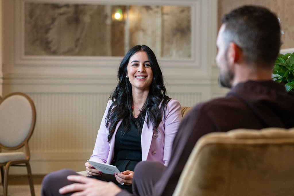 Candid conversation between two guests in a resort sitting room during a private interview