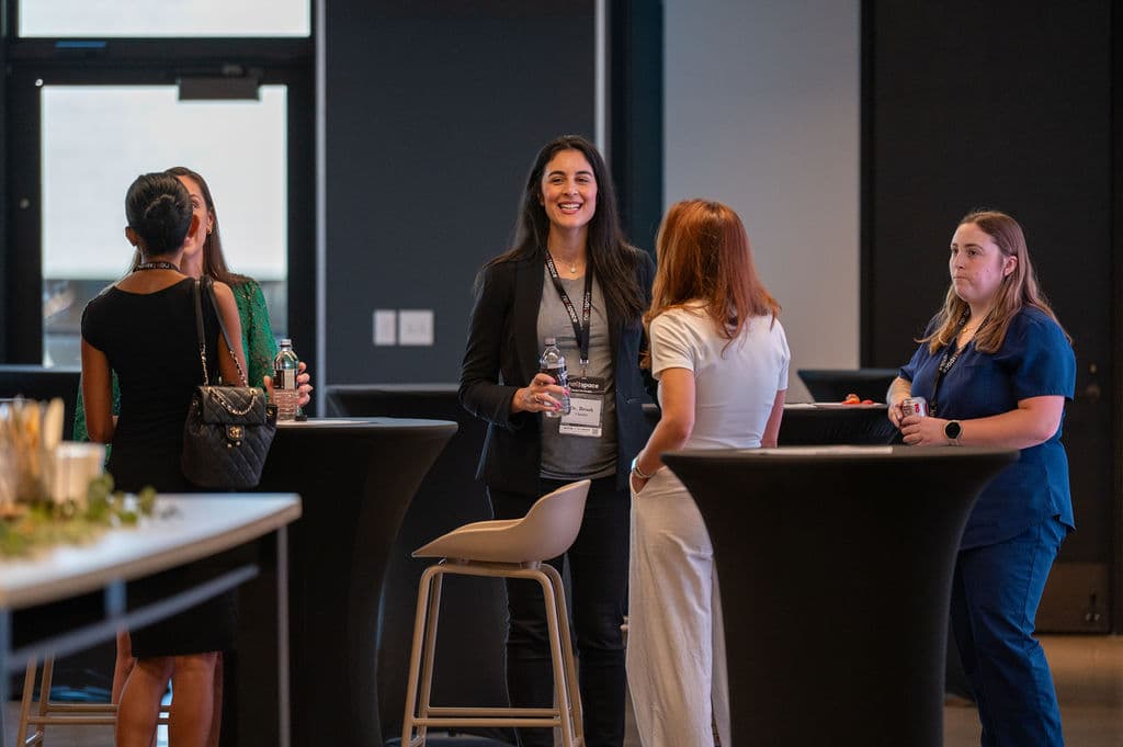Attendees talking over cocktail tables during a corporate networking reception